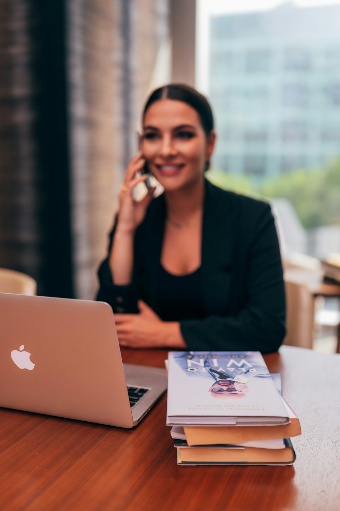 woman-in-black-blazer-sitting-by-the-table-with-macbook-slprv294uzo